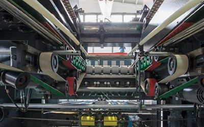 High-speed folding and gluing unit with vacuum belts