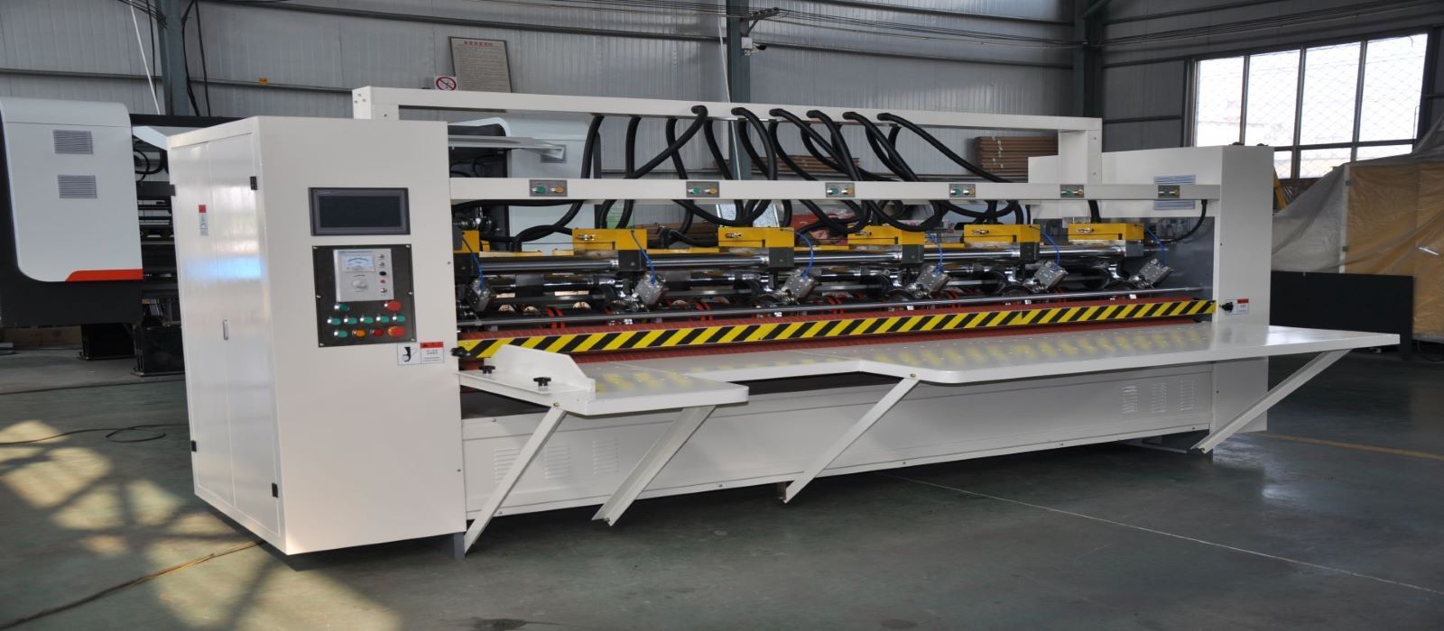 Thin blade slitter scorer machine in factory.